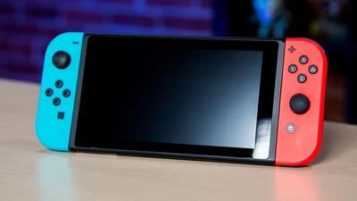 Nintendo Switch (в портативной конфигурации) с синим и красным Joy-Con’ами.