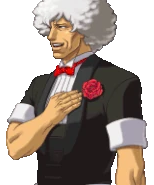 Улыбается с рукой на груди/говорит